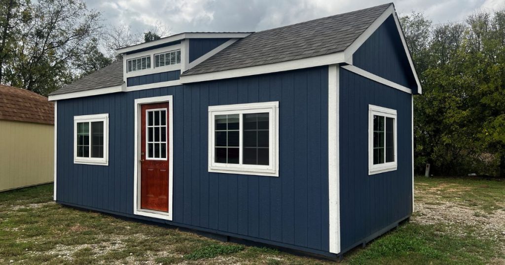 - Stunning blue chalet shed with metal roof and wooden door