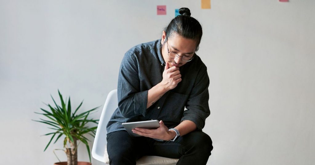 - man sits considering a design