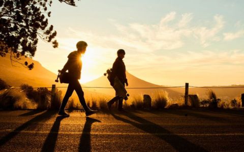 skateboarders walk at sunset enjoying a-simple-life