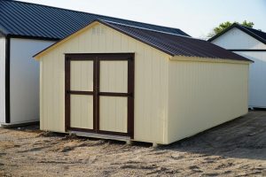  -  - A white shed with a brown roof available for sale.