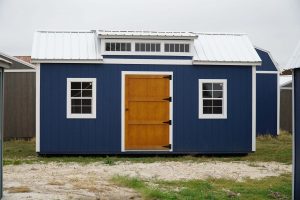 For sale: A blue shed with a wooden door, available at a nearby shed store.