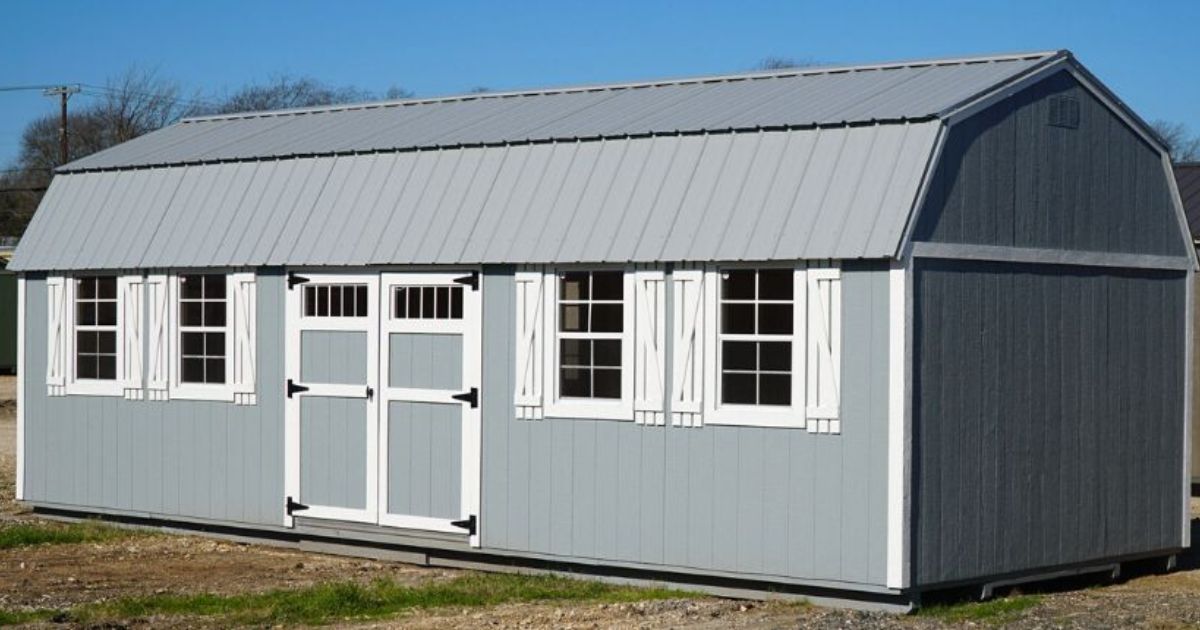 A gray shed with a white roof, available for sale.