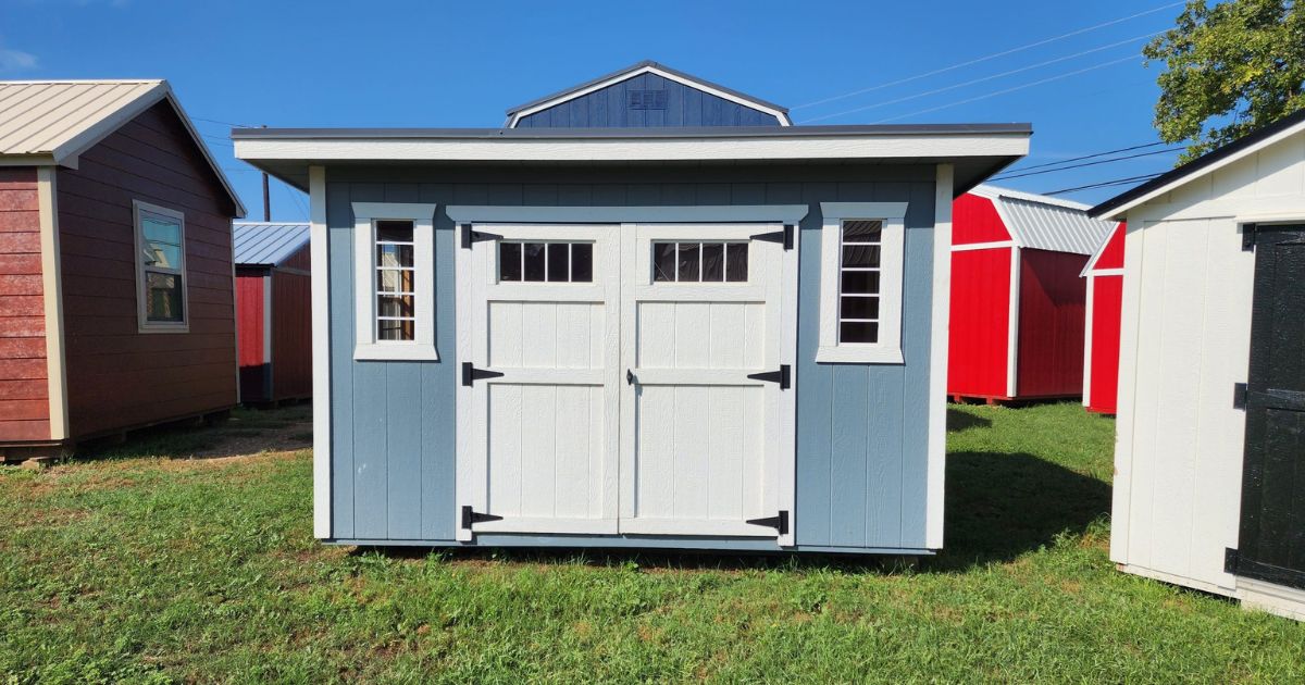 Two small sheds for sale in a grassy area.