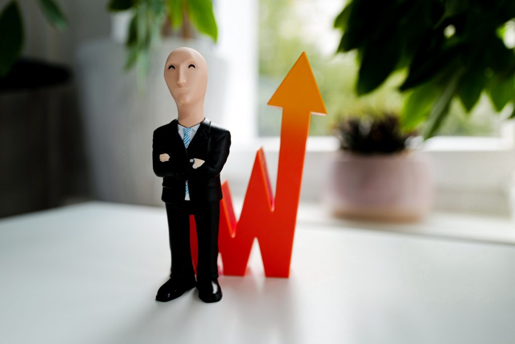 toy person next to a stock market arrow pointing up