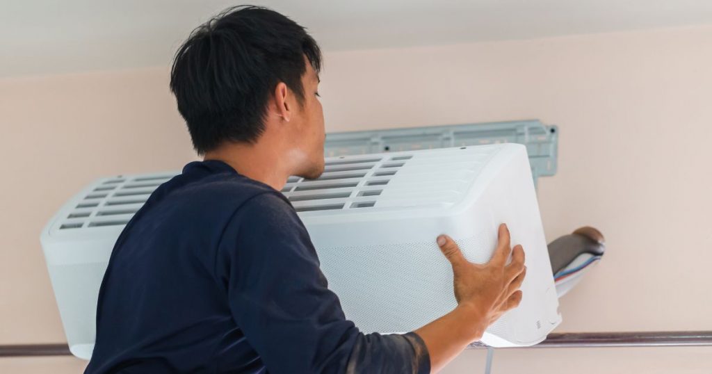 man installs air conditioner