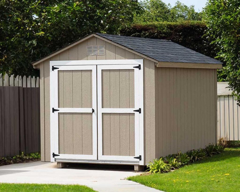 A tan shed for sale in a backyard.