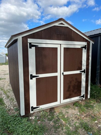 An 8x12 Utility Shed for sale in a field.