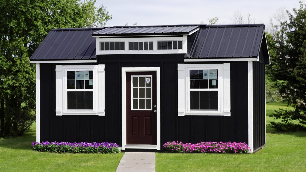 A black shed with a white roof.