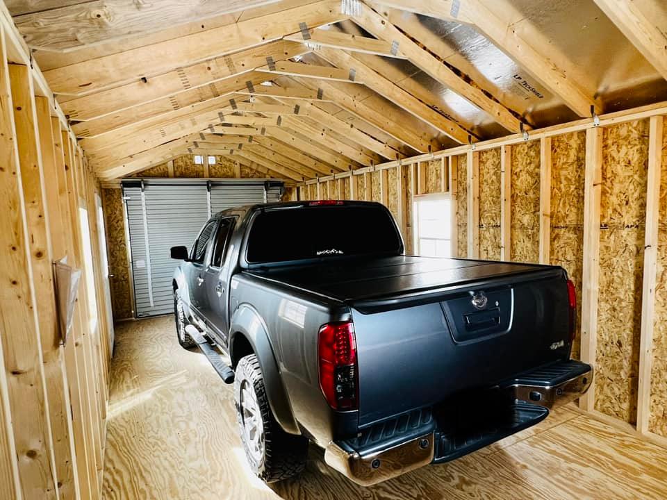 - An ebony truck is parked in a timber garage.
