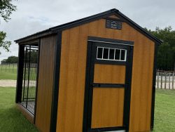 Sheds for Sale - Quality Guaranteed | LELAND'S SHEDS - Sheds for Sale - Quality Guaranteed | LELAND'S SHEDS - Orange and black wooden shed with a small white window, set on a grassy field under a cloudy sky.
