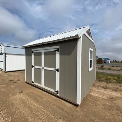 Two 10x12 Garden Sheds for sale sitting on a dirt lot.