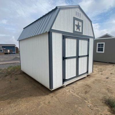 A 10x12 Lofted Barn Shed for sale near me, located in a dirt lot.