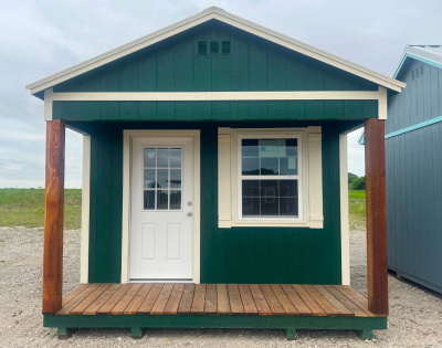 A green and white 12x16 Cabinette Shed on a gravel lot available for sale.