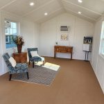 A living room with chairs and a 12x24 Diamond Cabinette Shed, featuring a cozy and inviting atmosphere. - LELAND'S SHEDS - A living room with chairs and a 12x24 Diamond Cabinette Shed, featuring a cozy and inviting atmosphere.