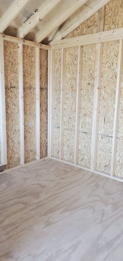 The inside of a 12x16 Cabinette Shed, available for sale with wood flooring and walls.