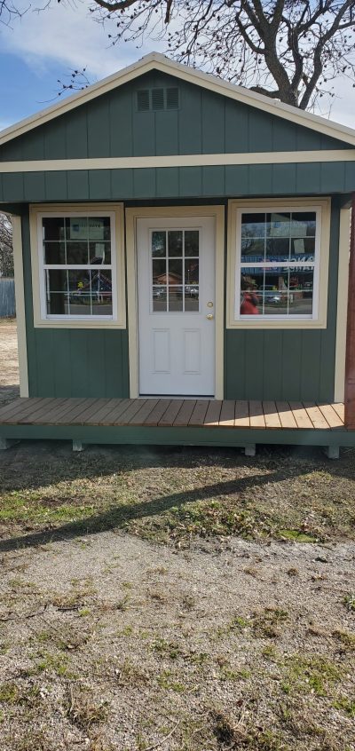 A green and white 12x16 Cabinette shed with a porch, available for sale.