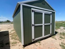 For sale: A 12x24 Utility Shed in a dirt field.