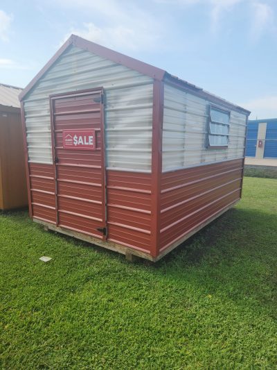 An 8x12 Greenhouse for sale sitting on a grassy field.