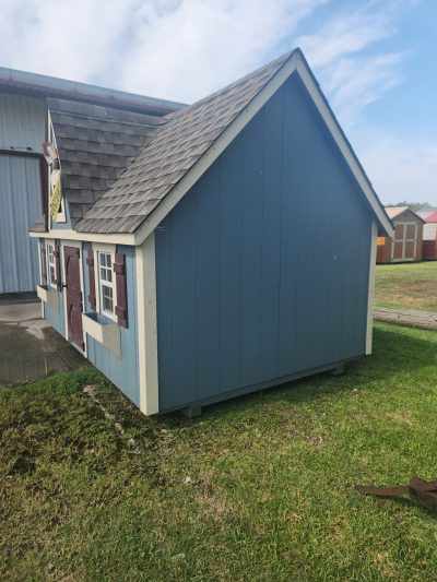 An 8x12 Victorian Playhouse with a blue roof for sale.