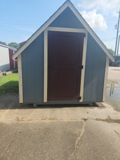 A small 8x12 Victorian Playhouse for sale near me in a parking lot.