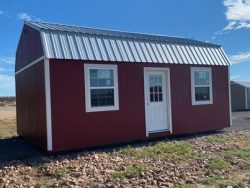 For sale 16x24 Lofted Barn Shed: A red shed with a metal roof in a field.