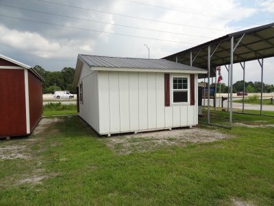 Two 16x30 Cottage Sheds for sale sitting on a grassy area.