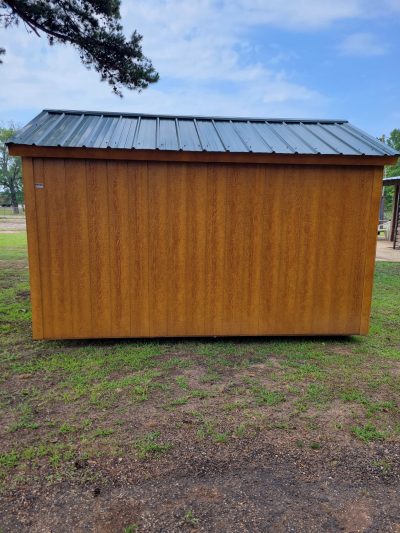 An 8x12 Basic Shed with a metal roof in a grassy area is available for sheds sale near me.