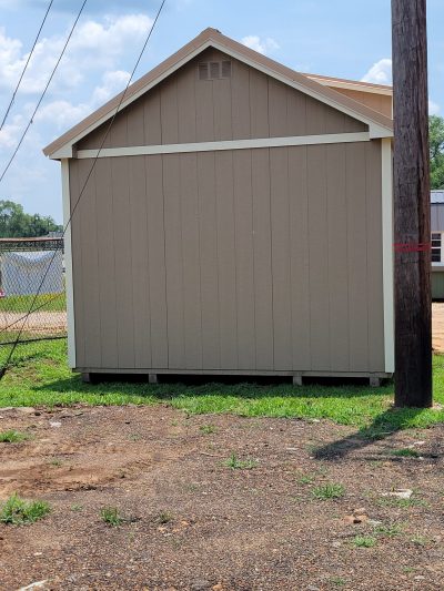 A 12x20 Chalet Shed sitting on a dirt lot, available for sale.