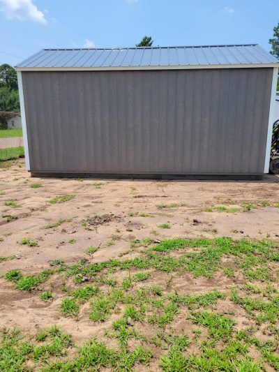 A 12x20 Garage Shed for sale sitting in a dirt field.