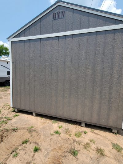 A 12x20 Garage Shed for sale sitting in a dirt lot.