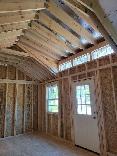 A room featuring wood framing and windows, perfect for those in search of 12x20 Chalet Sheds for sale near me or a shed store near me. Explore this delightful space, suitable for various functions, and envision.