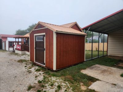 A 10x10 Utility Shed with a red roof available for sale.