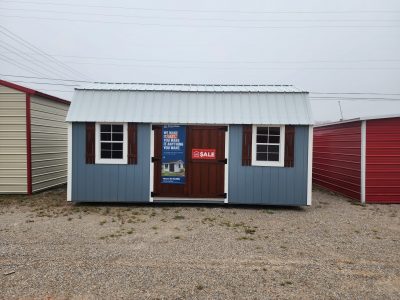 A blue and red 10x20 Lofted Barn with a for sale sign on it.