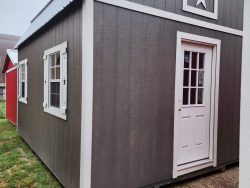 A gray and white 14x16 Lofted Barn shed with a star on it, available for sale.