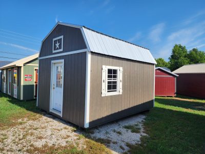 A 14x16 Lofted Barn for sale, sitting in a grassy area.