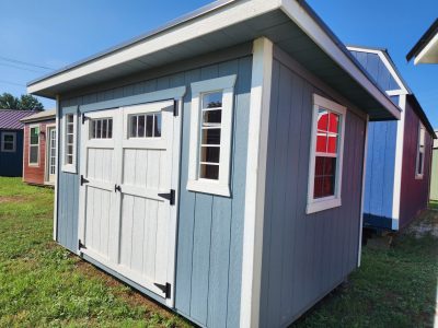 An 8x12 Studio Shed for sale, sitting on a grassy area.