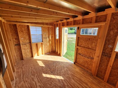 The interior of a cozy tiny house with charming wooden walls, perfect for those in search of an 8x12 Studio Shed or looking for sheds on sale at a nearby shed store.