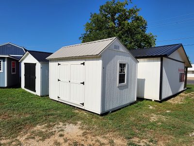 A row of 10x12 Garden Sheds for sale in a yard.