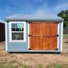 A 10x12 Utility Shed with a wooden door on sale.