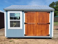 A 10x12 Utility Shed with a wooden door on sale.