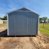 A 10x12 Utility Shed for sale sitting in a dirt field.