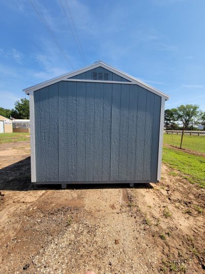 A 10x12 Utility Shed for sale sitting in a dirt field.