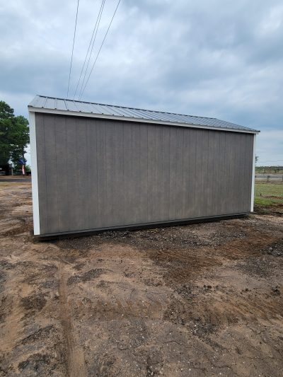 A gray 12x20 Garage Shed, available for sheds sale near me or on sale, sitting in a dirt field.