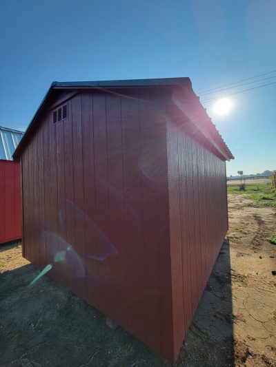 A red 10x12 Basic Shed with a sun shining on it, available for sale at a nearby shed store.
