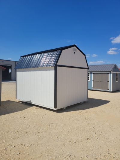 A white and black 10x12 Lofted Barn Shed for sale, with a metal roof.