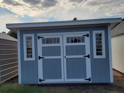An 8x12 Studio Shed with a white door, available for sale.