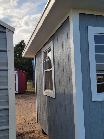 An 8x12 Studio Shed with a blue window and a blue door available for sale.