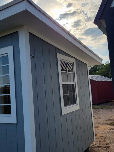 For sale: An 8x12 Studio Shed with windows and a blue roof.