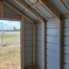 Explore a spacious 8x12 Metal Shed, featuring an inviting open door.