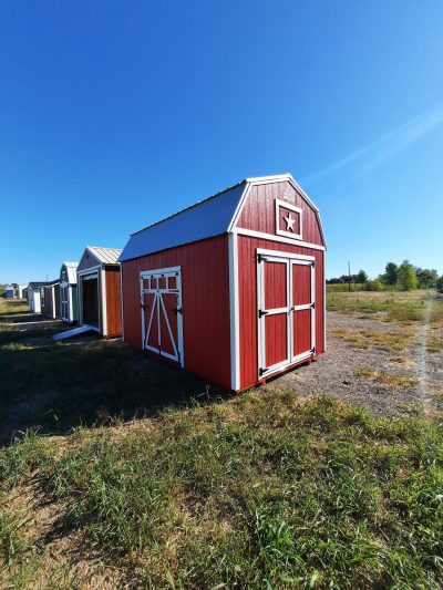 Two 10x16 Lofted Barn Sheds on sale in a field.